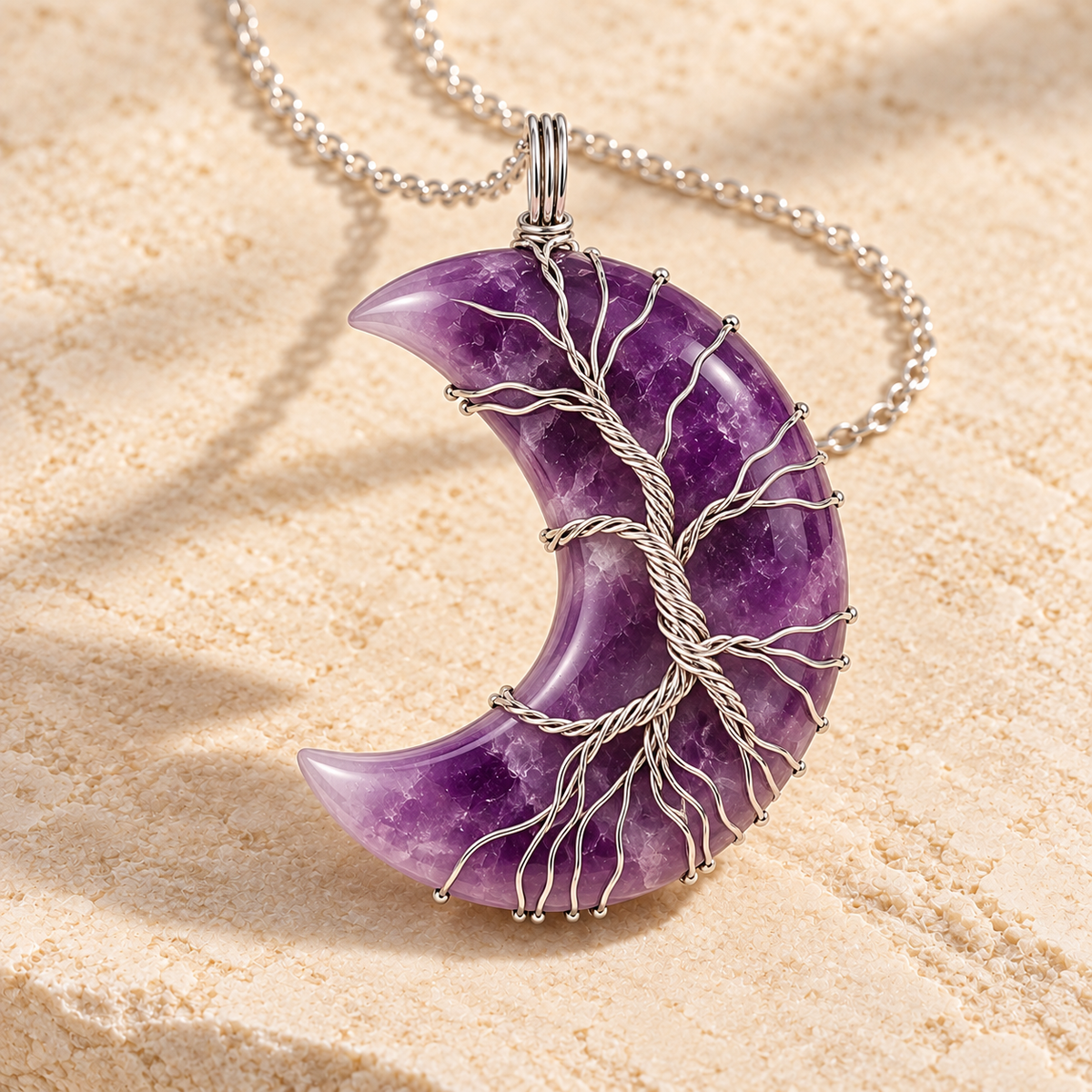Amethyst crescent moon necklace wrapped with a silver-tone Tree of Life on a warm cream background.