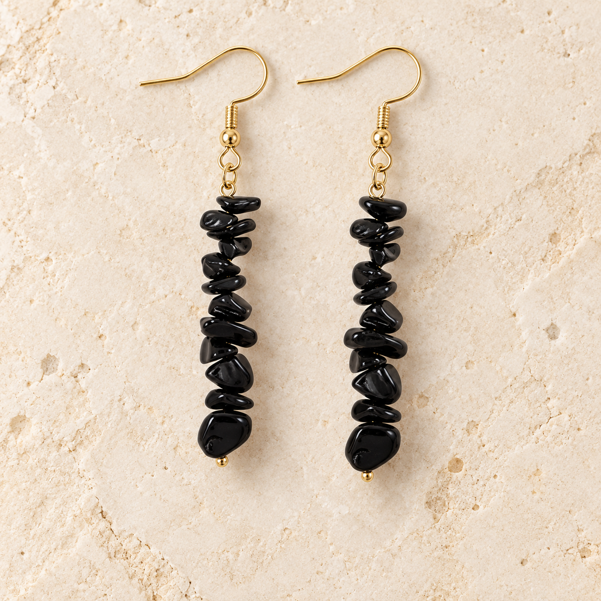 Black Obsidian stone chip drop earrings with gold-tone hooks on a warm cream background.