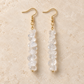 Clear Quartz stone chip drop earrings with gold-tone hooks on a warm cream background.