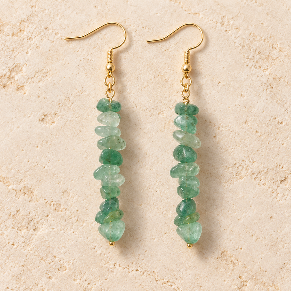 Green Aventurine stone chip drop earrings with gold-tone hooks on a warm cream background.