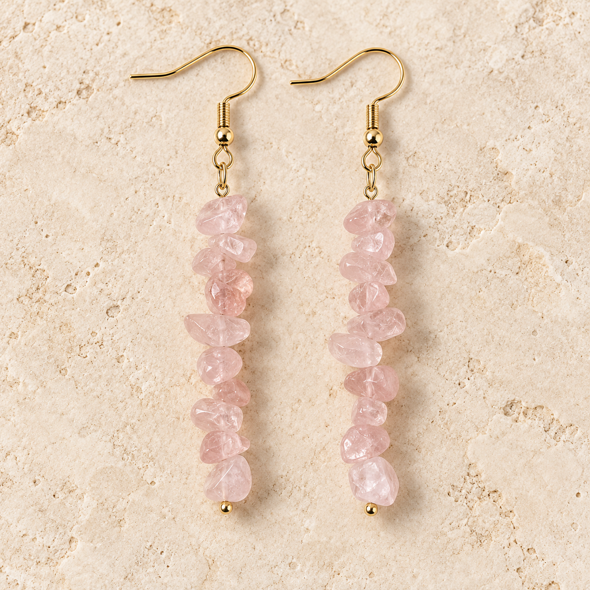 Rose Quartz stone chip drop earrings with gold-tone hooks on a warm cream background.