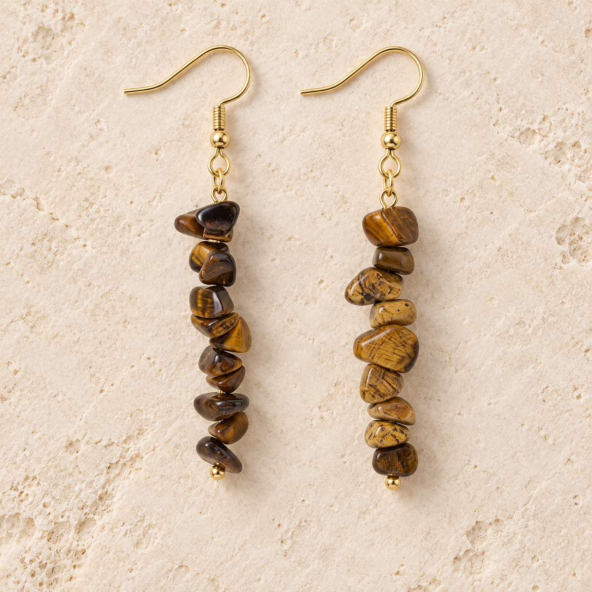 Tiger's Eye stone chip drop earrings with gold-tone hooks on a warm cream background.