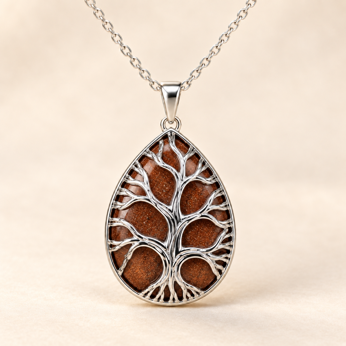 Gold Sandstone teardrop Tree of Life necklace on a warm cream background.