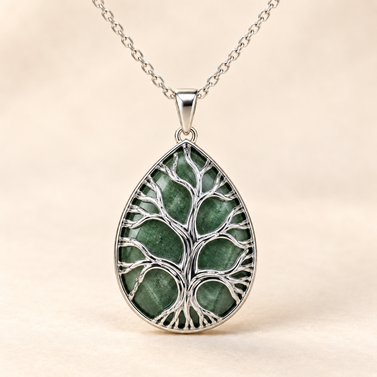 Green Aventurine teardrop Tree of Life necklace on a warm cream background.