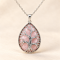 Rose Quartz teardrop Tree of Life necklace on a warm cream background.
